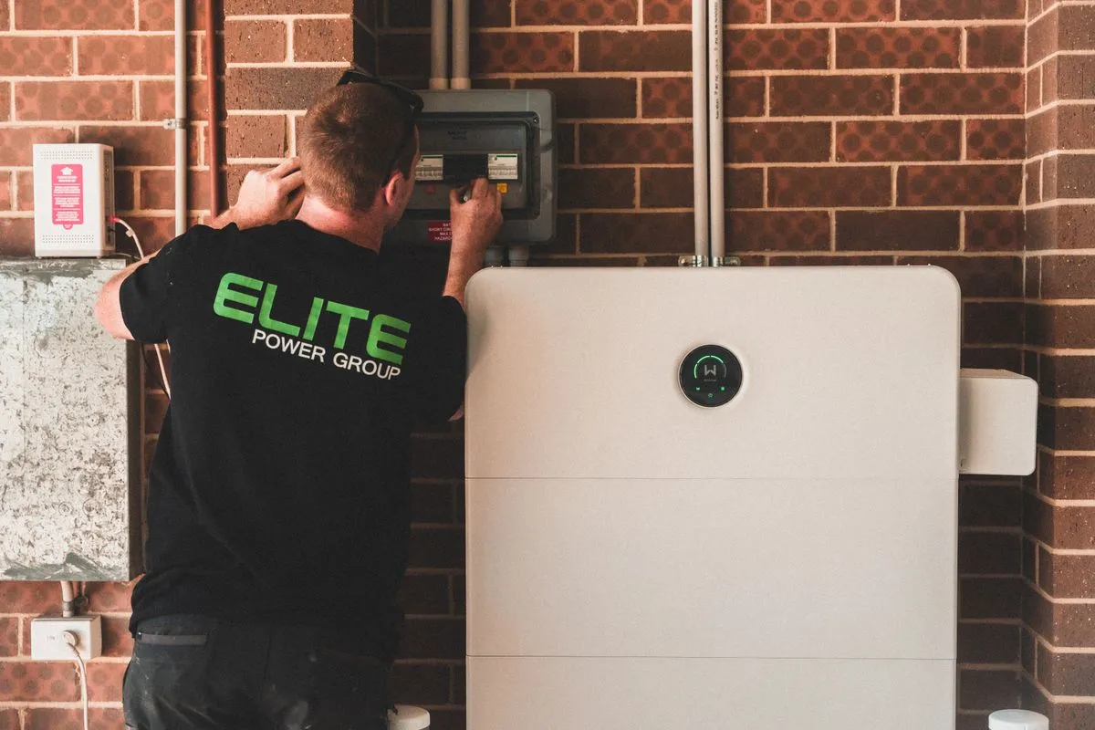 Électricien installant une batterie de stockage domestique