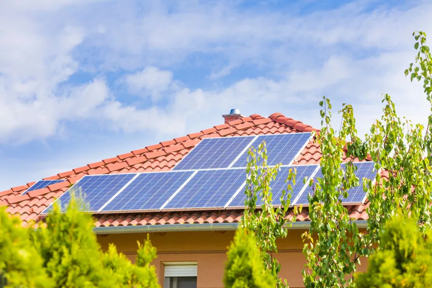 Installateurs posant des panneaux photovoltaïques sur le toit d'une maison